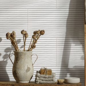 Modern interior wall installation featuring textured, three-dimensional fluted accent wall tiles in the light neutral Whisper colorway from the Earthen collection.